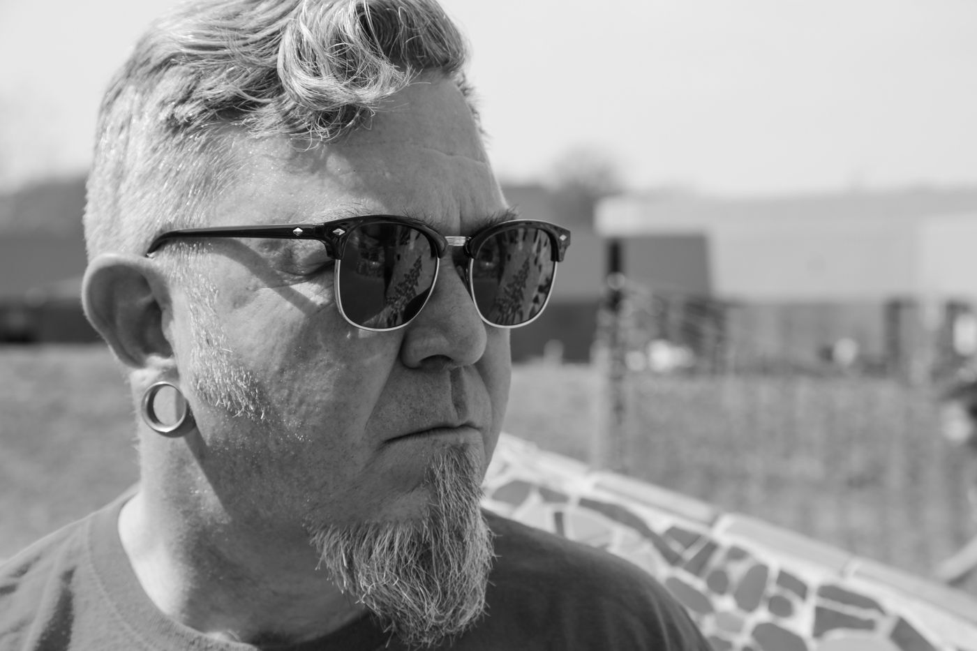 Hip-hop artist Mighty Rock in sunglasses, photographed in black and white